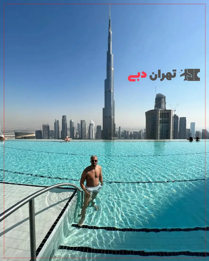 view of khalifa tower from infinity pool aura and a man standig fronted in pool -خرید ووچر استخر اینفینیتی